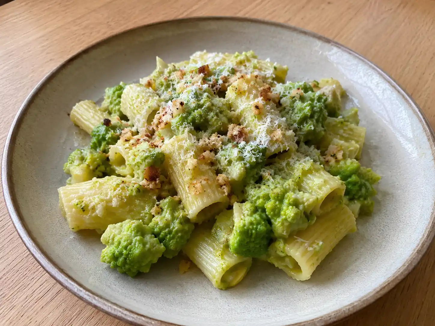 Broccoli romanesco pasta cremosa con rigatoni, cimette verdi e pane tostato nel piatto