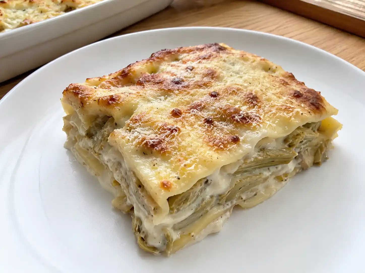 Lasagne ai carciofi cremose con strati di sfoglia, besciamella e superficie dorata al forno