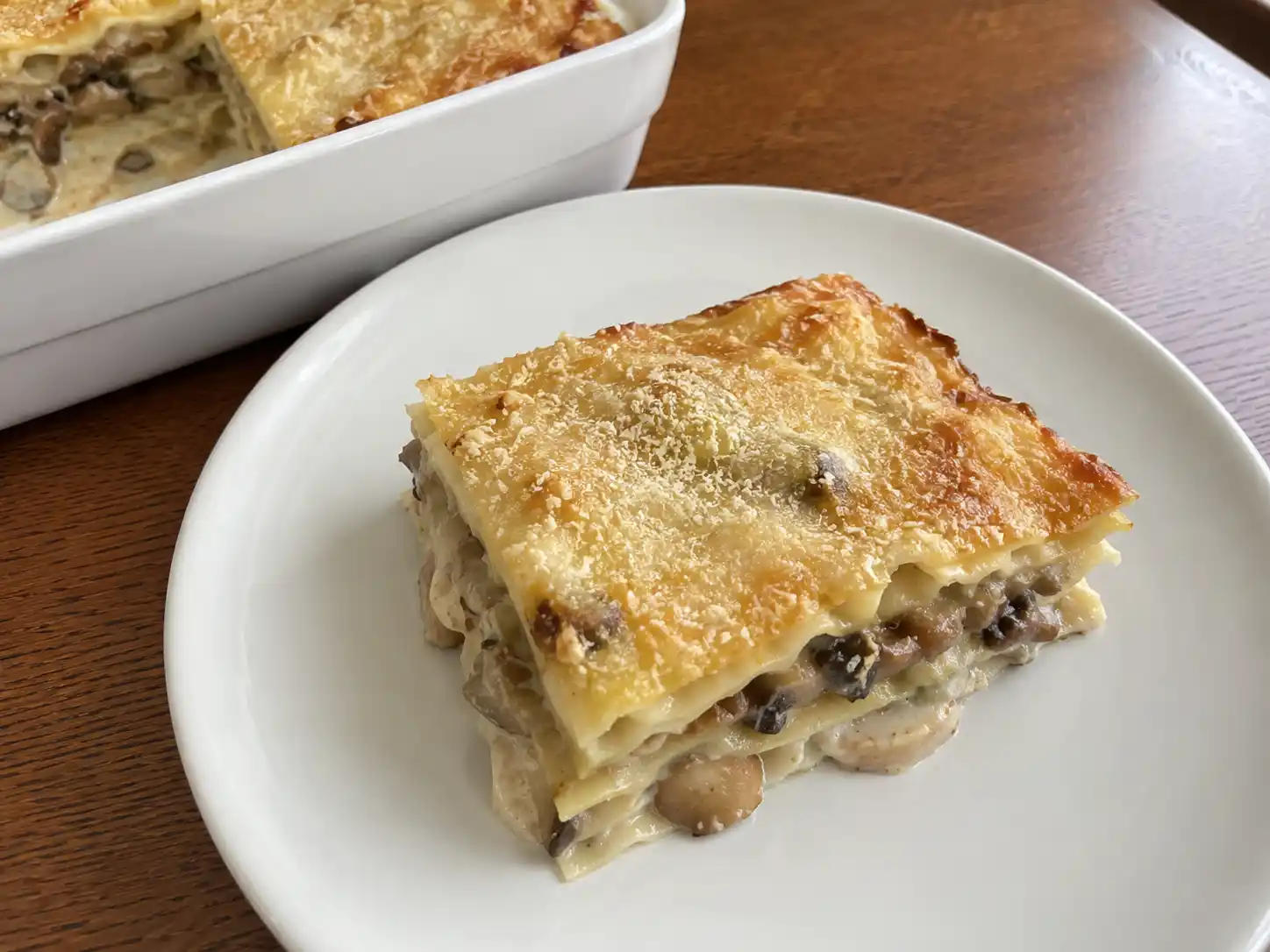 Lasagne ai funghi bianche in teglia, cremose e dorate, con strati di besciamella e funghi