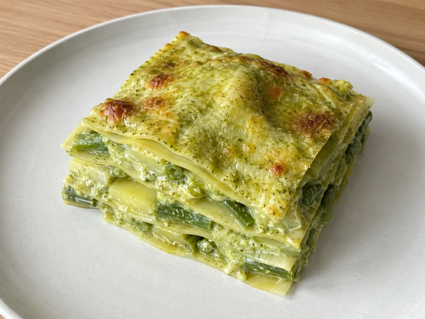 Lasagne al pesto con patate e fagiolini, cremose e dorate in teglia bianca
