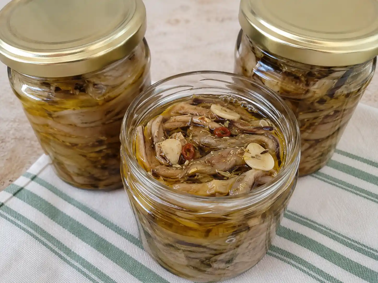 Melanzane sott'olio ricetta tradizionale in vasetto con listarelle, aglio, origano e peperoncino immerse nell'olio