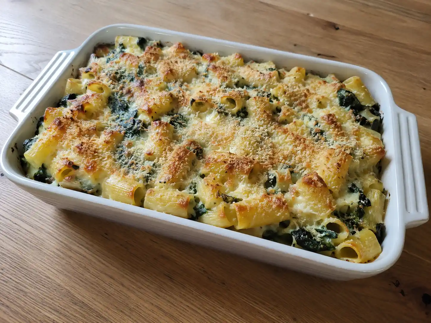 Pasta al forno spinaci e ricotta in pirofila, cremosa e gratinata con mozzarella filante