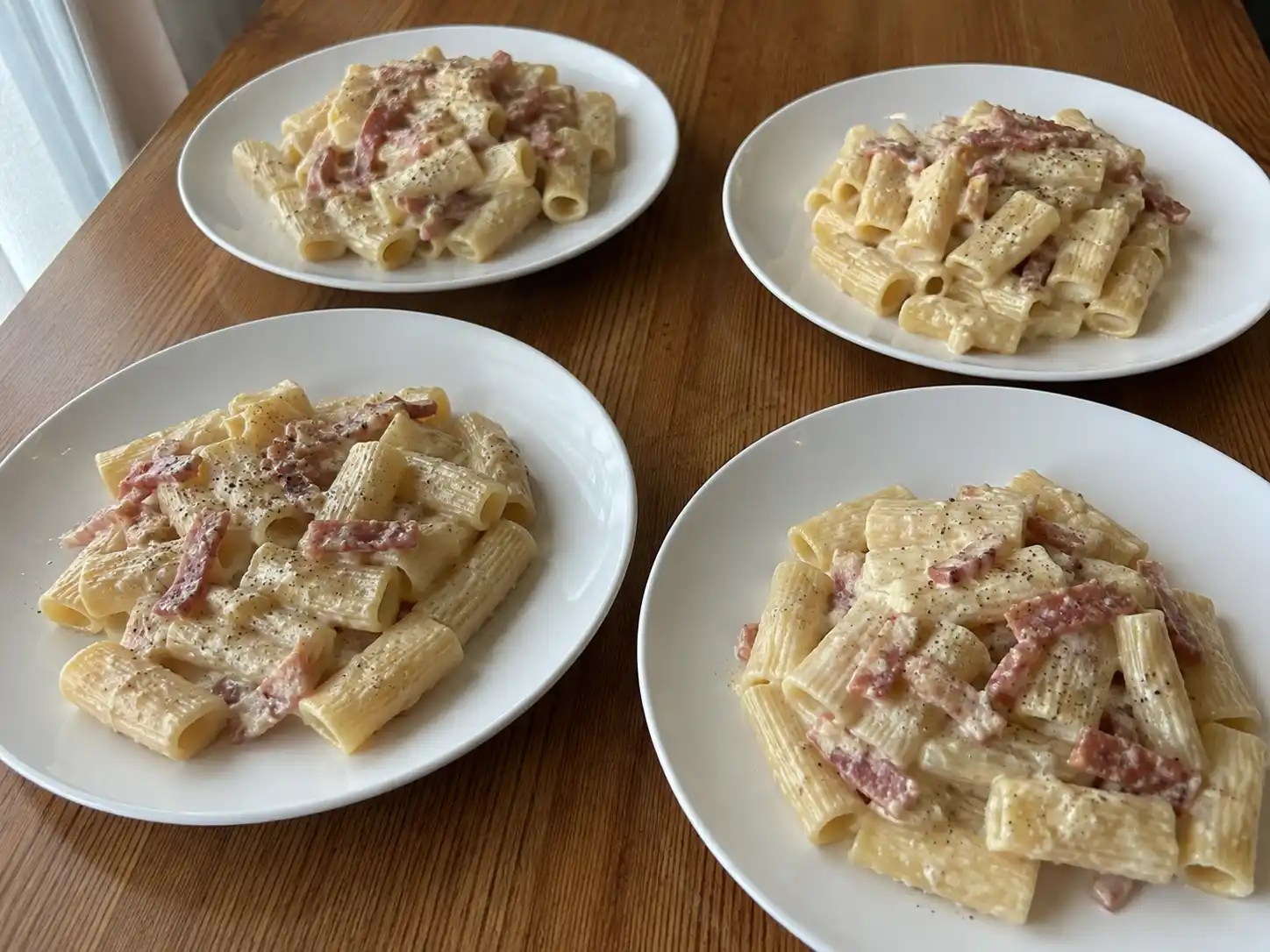 Pasta al gorgonzola e speck cremosa con rigatoni rigati, salsa chiara e speck rosolato