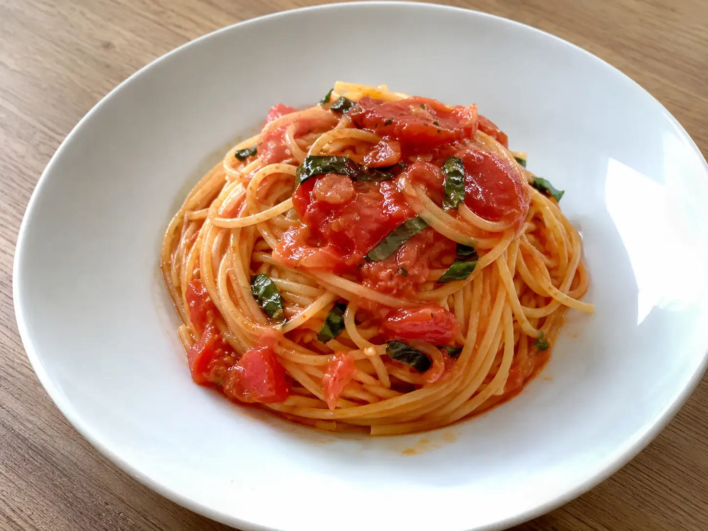 Pasta al pomodoro fresco con spaghetti, salsa rustica di pomodori maturi e basilico nel piatto