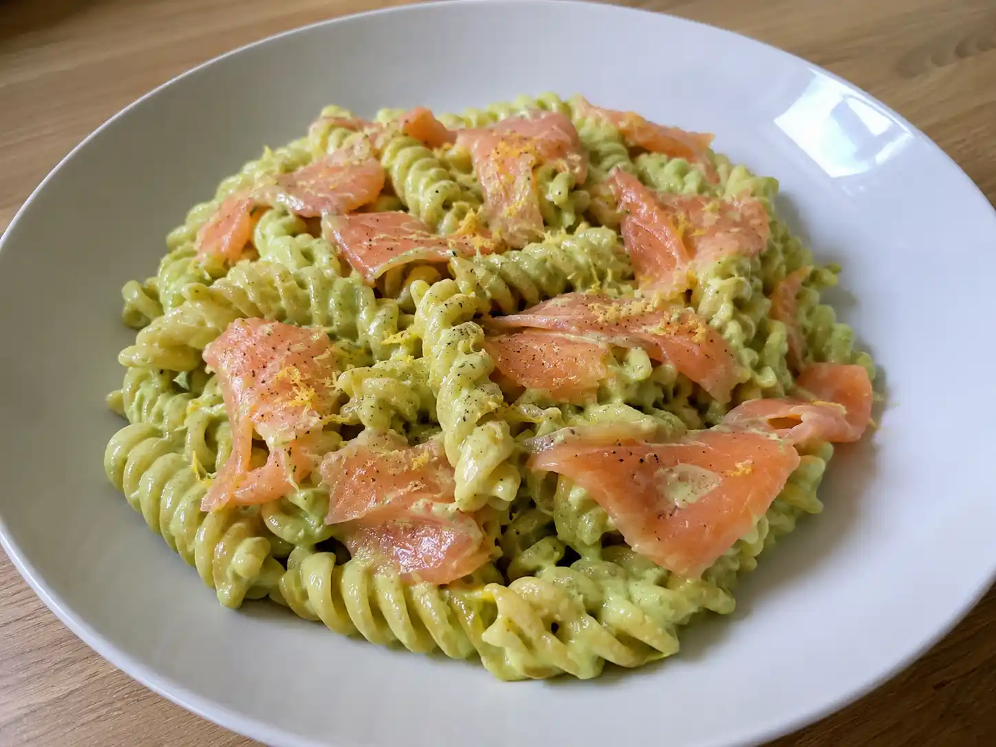 Pasta avocado e salmone cremosa con fusilli verdi, strisce di salmone affumicato e limone
