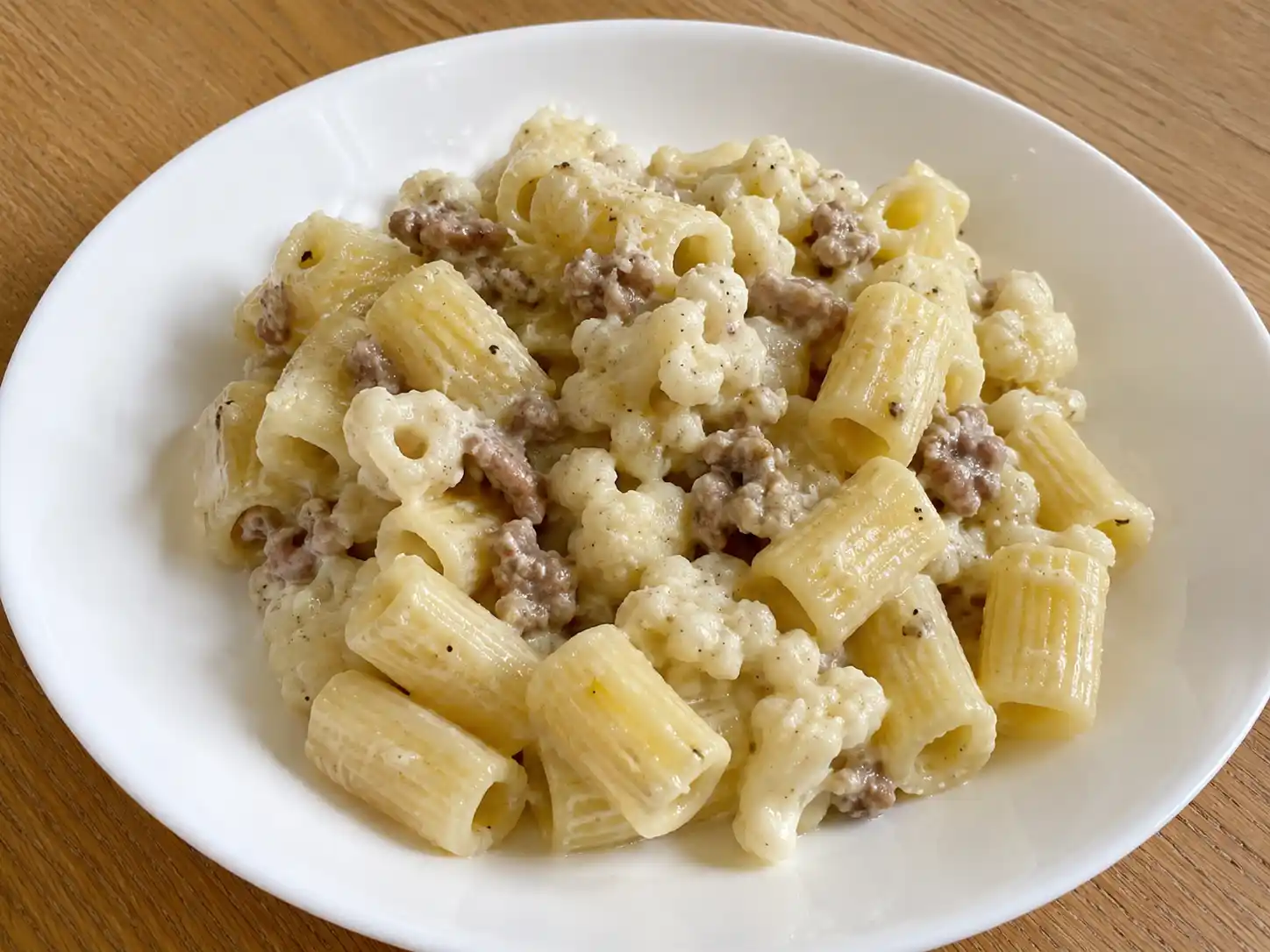Pasta cavolfiore e salsiccia cremosa con mezze maniche, cimette tenere e salsiccia rosolata
