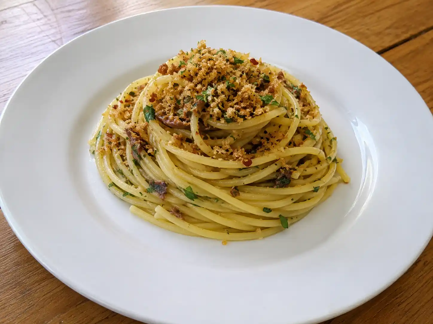 Pasta con acciughe e mollica atturrata con spaghetti dorati, prezzemolo e pangrattato croccante
