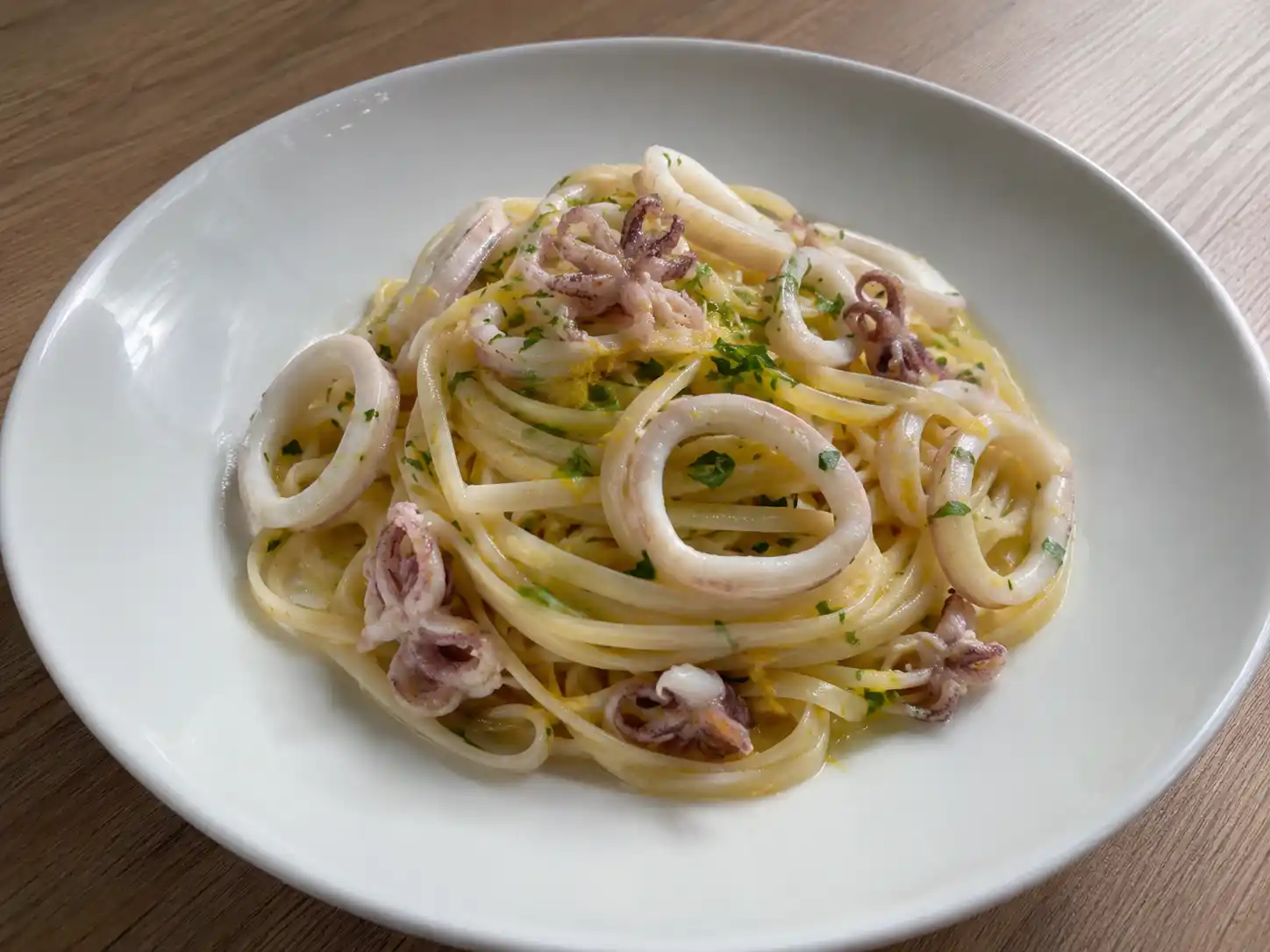 Pasta con calamari in bianco con linguine, anelli teneri, prezzemolo e scorza di limone