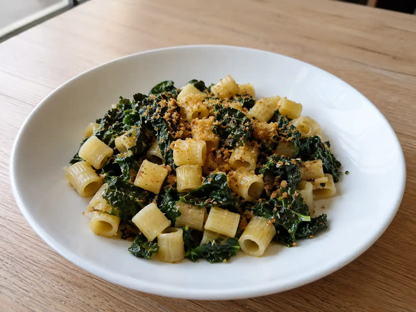 Pasta con cavolo nero e acciughe con pangrattato tostato e condimento verde ben mantecato