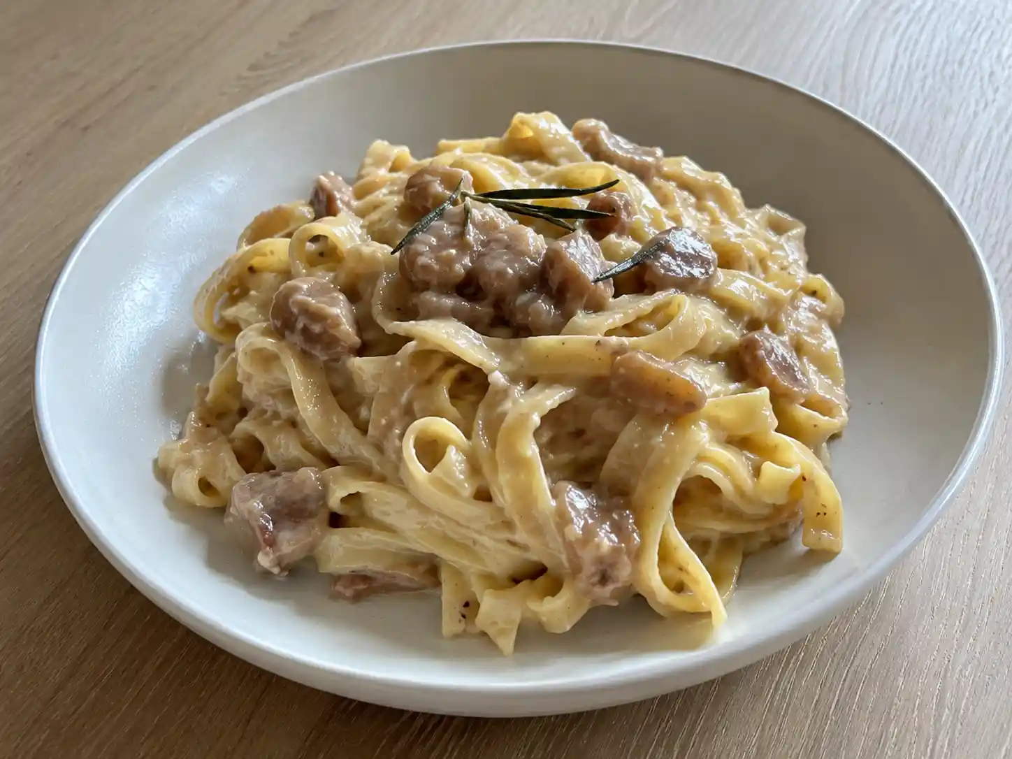 Pasta con le castagne cremosa con rosmarino e pecorino, servita in piatto fondo chiaro
