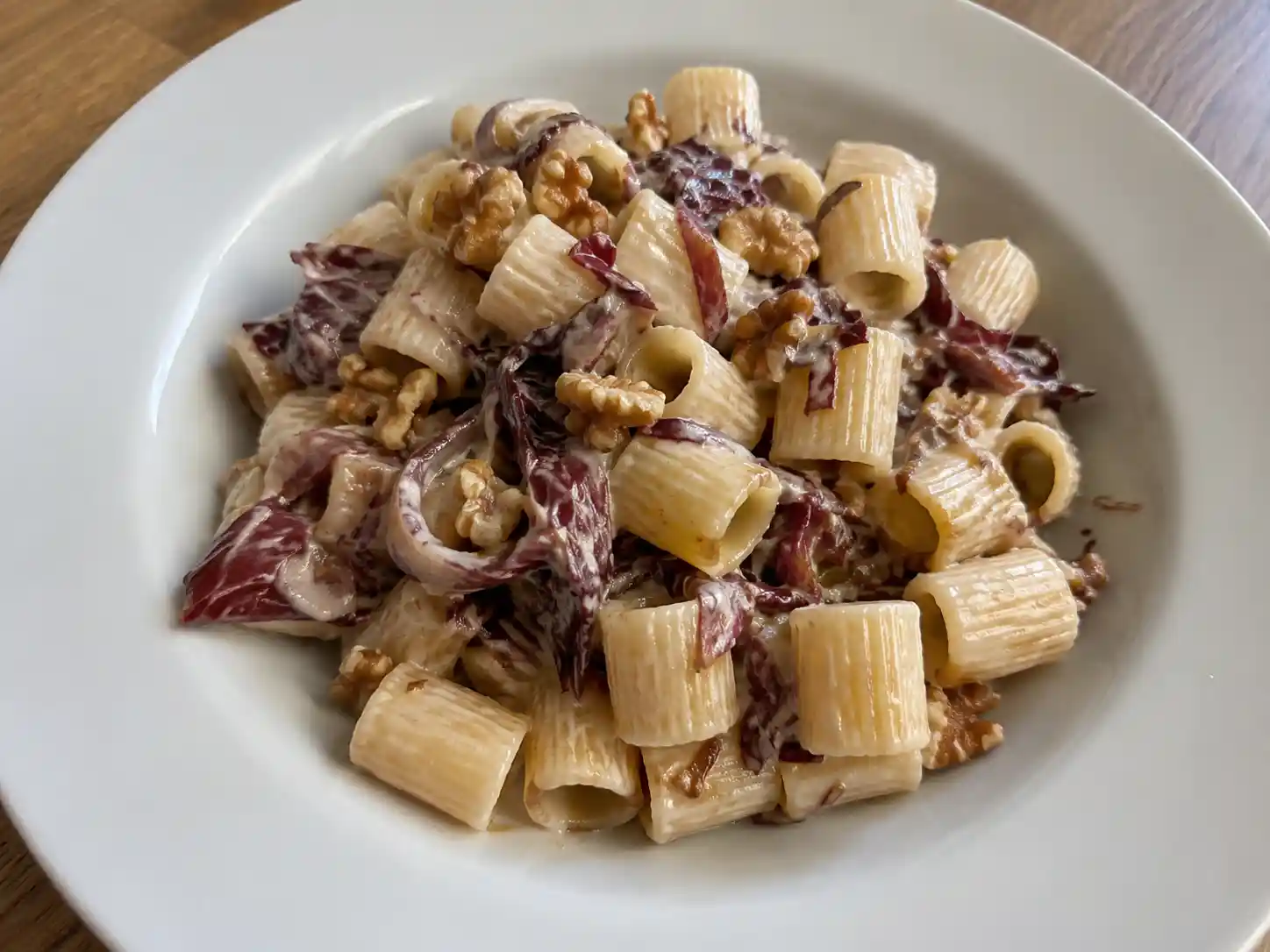 Pasta con radicchio e noci cremosa con gorgonzola dolce, servita calda in un piatto fondo
