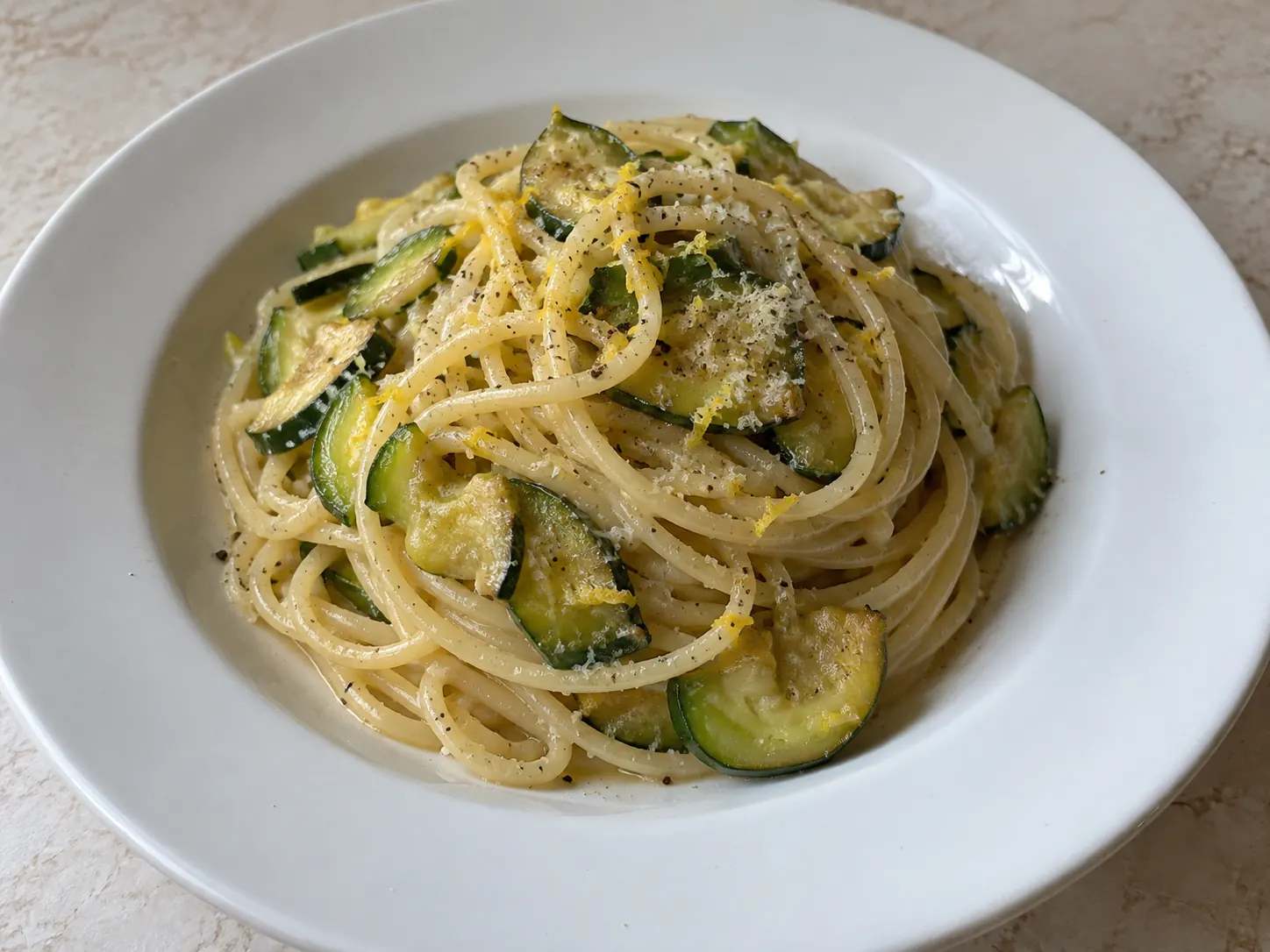 Pasta con zucchine e limone cremosa con scorza grattugiata e zucchine dorate in padella