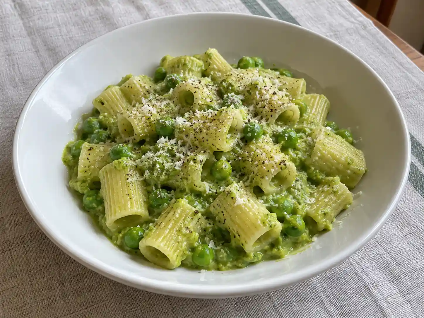 Pasta crema di piselli con mezze maniche, salsa verde vellutata e piselli interi nel piatto