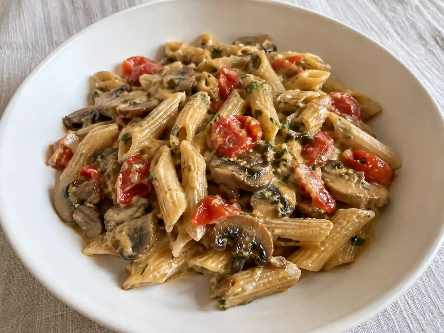 Pasta funghi e pomodorini con penne rigate, champignon e ciliegini saltati in padella