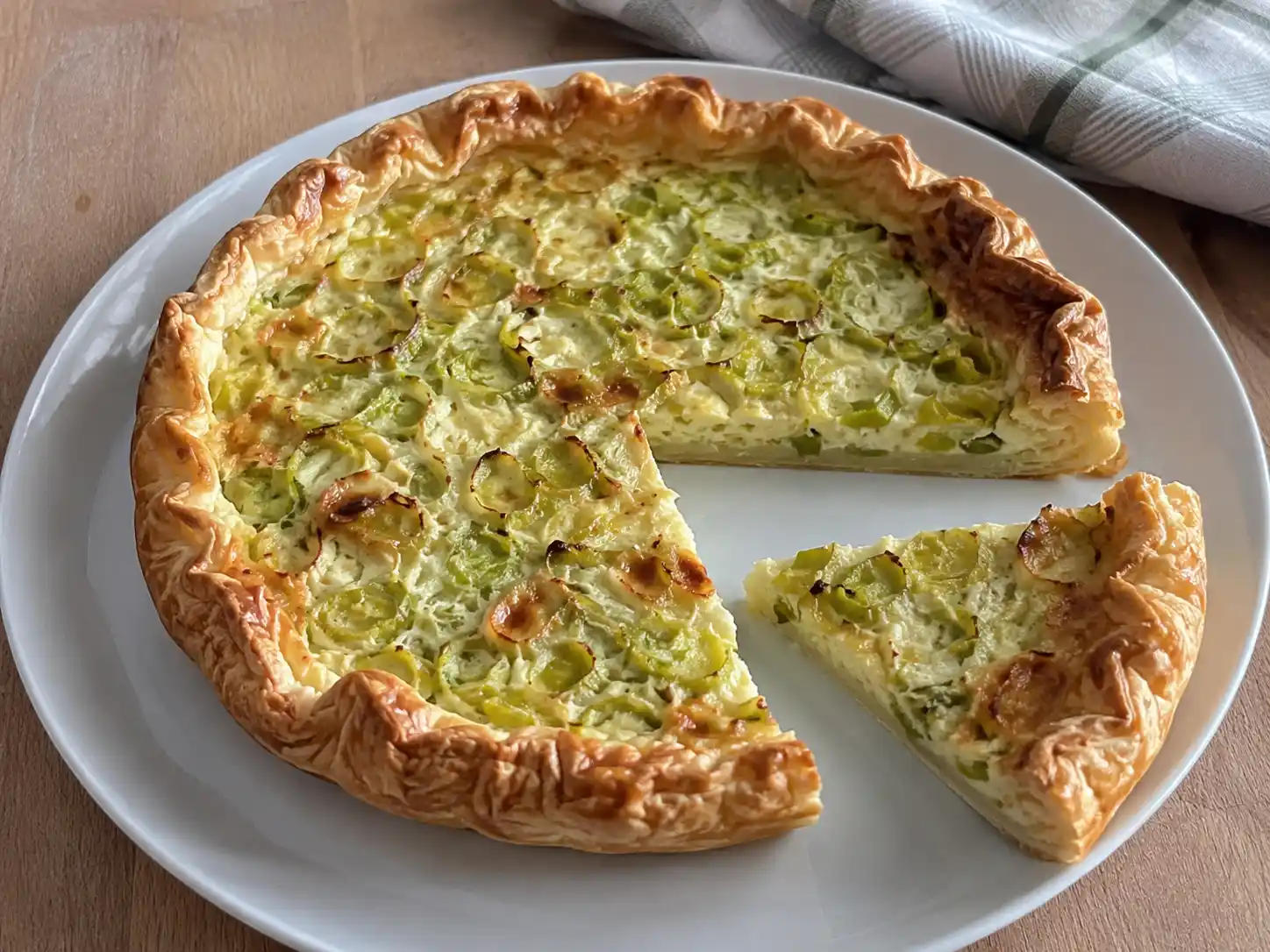Torta salata ai porri e ricotta in fetta, con sfoglia dorata e ripieno chiaro ai porri