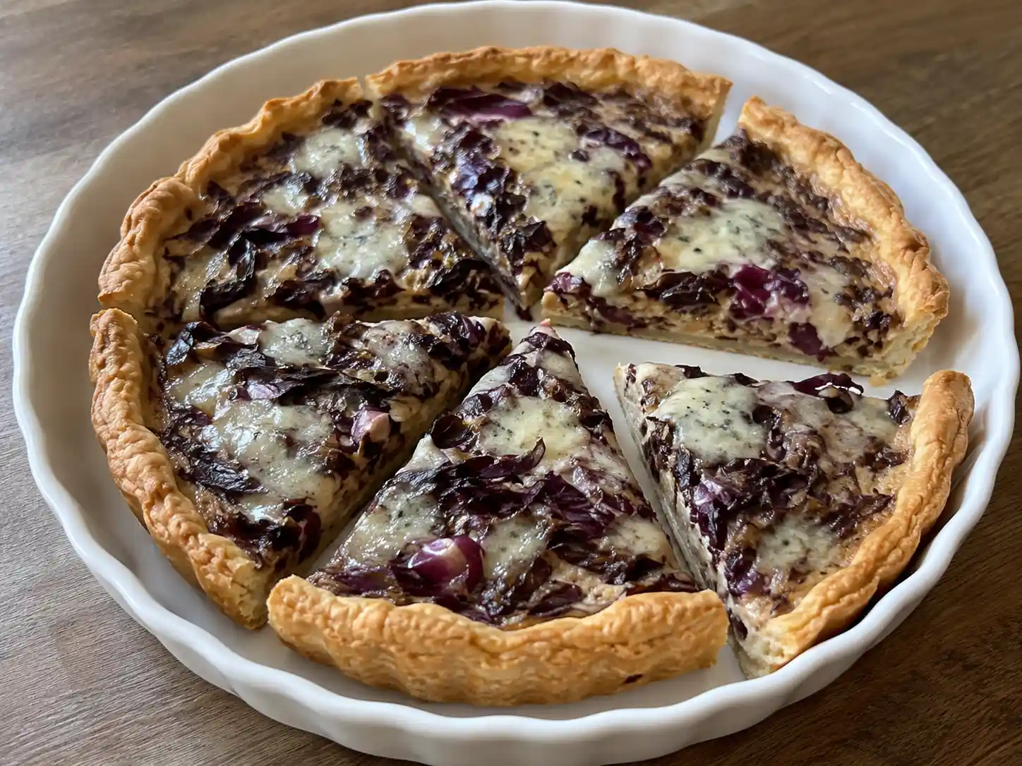 Torta salata radicchio e gorgonzola tagliata a fette, con ripieno viola e crema chiara