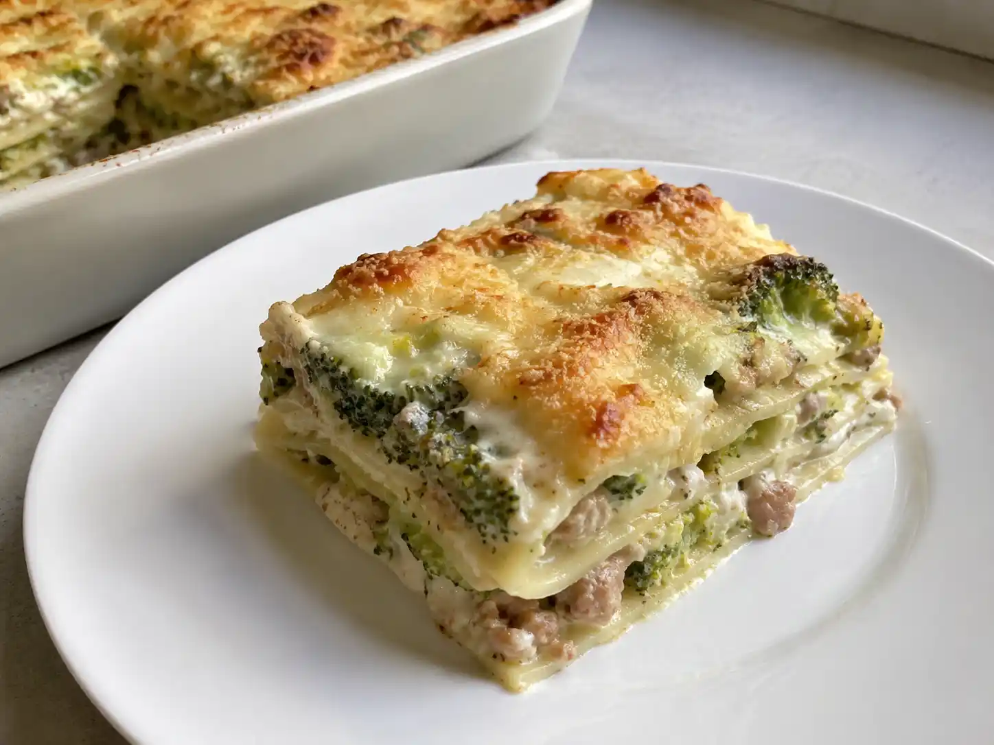 Lasagne broccoli e salsiccia bianche in teglia, con strati cremosi e superficie dorata