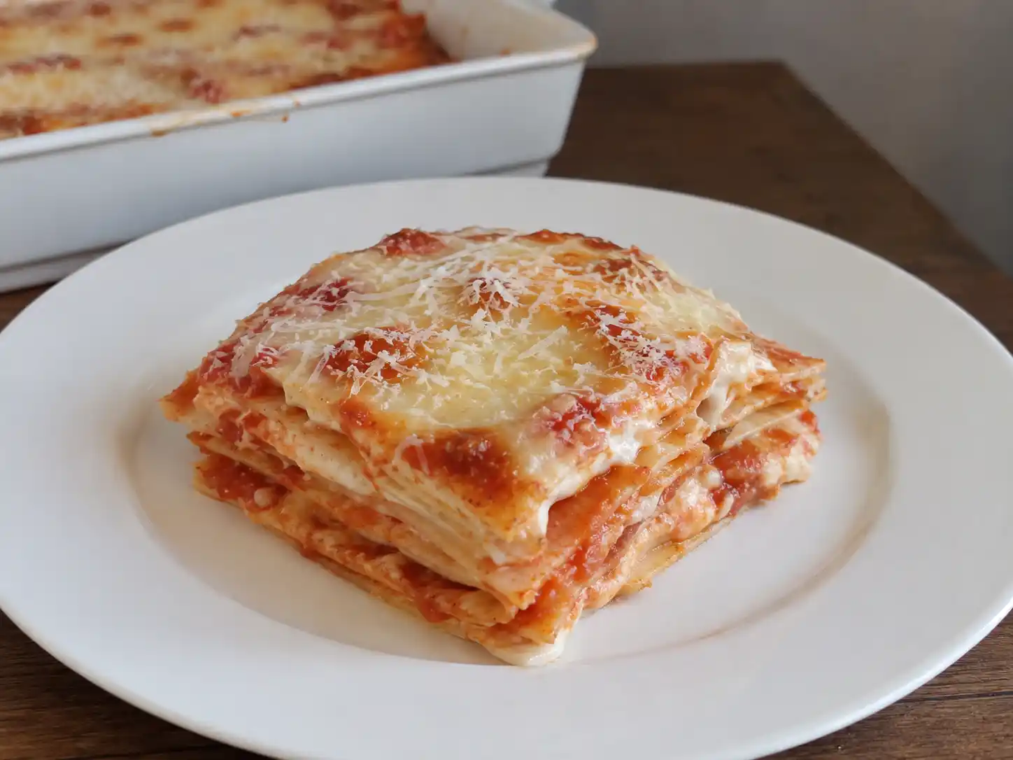 Lasagne con pane carasau al pomodoro in teglia, con strati sottili, besciamella e mozzarella filante