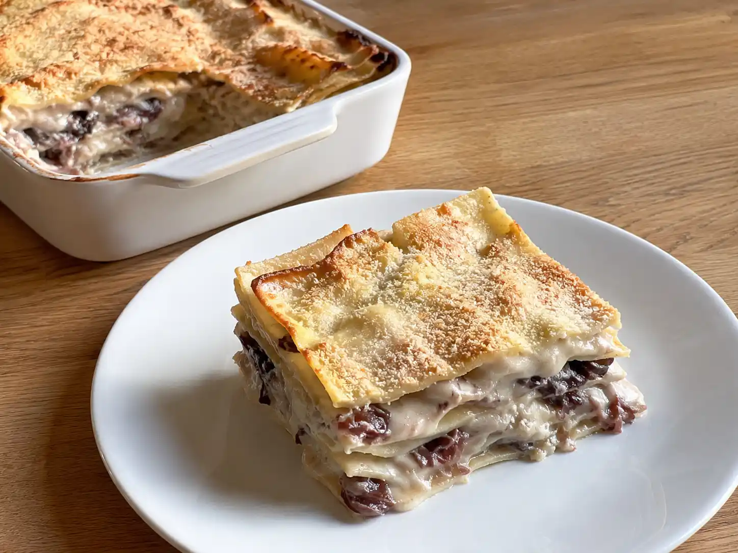 Lasagne radicchio e gorgonzola in pirofila, strati cremosi con superficie dorata e radicchio visibile