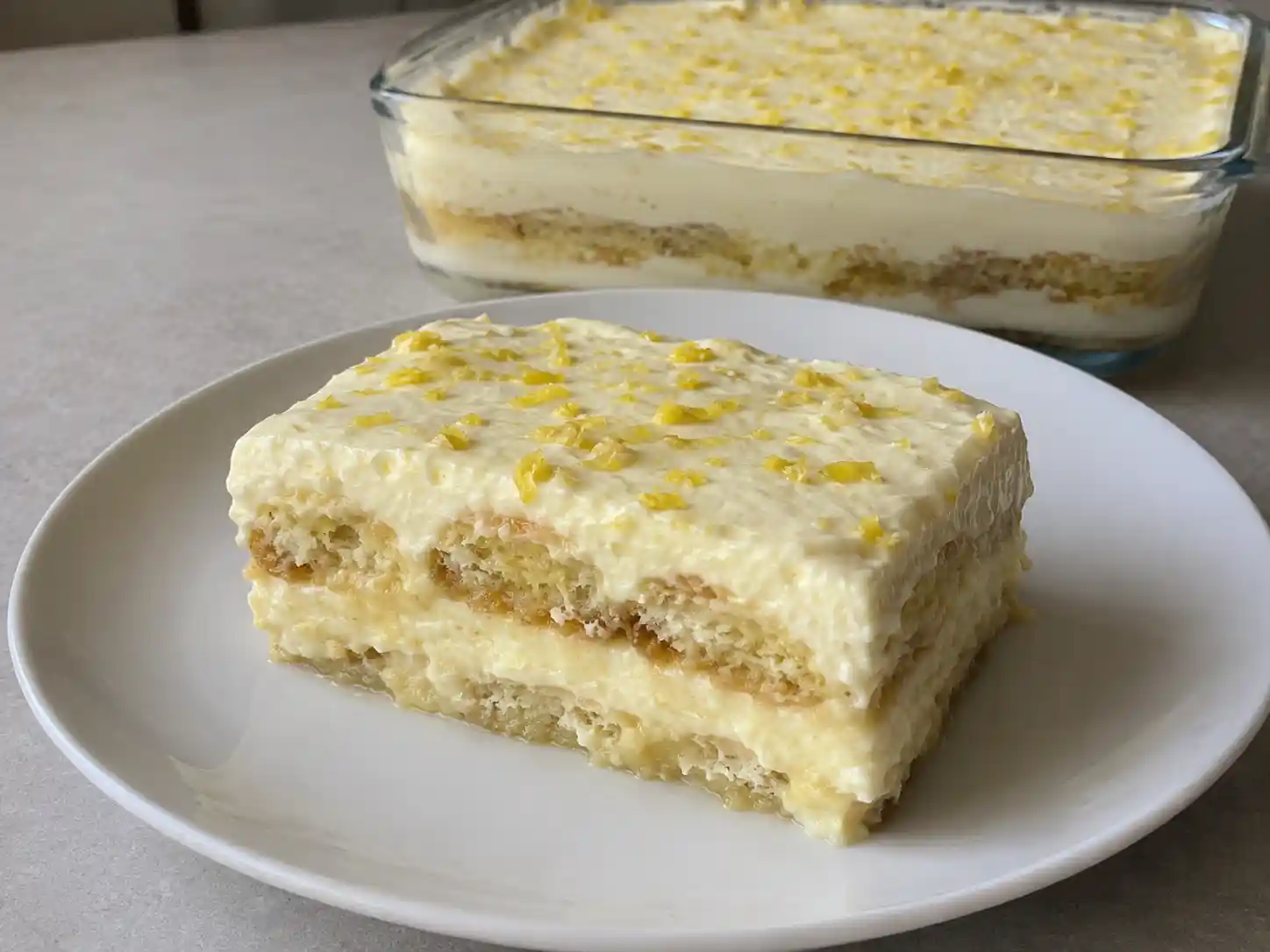 Tiramisù al limone ricetta originale in pirofila con crema chiara, savoiardi e scorza