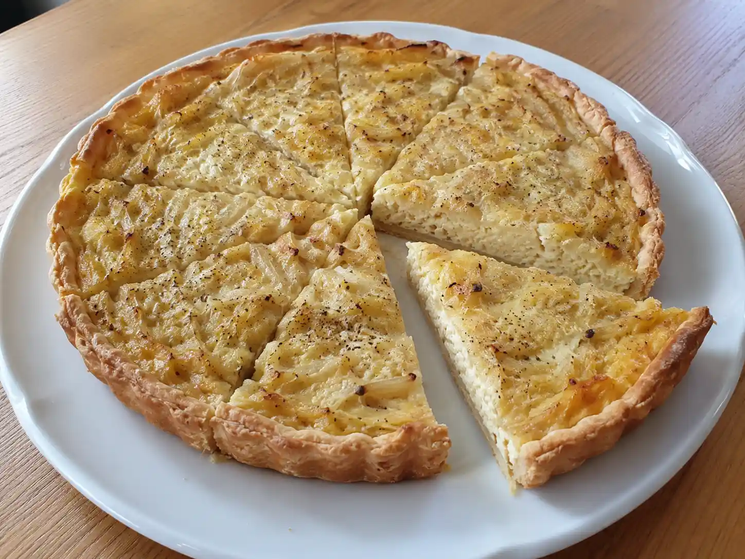 Torta salata alla cipolla dorata con brisée croccante e ripieno morbido in teglia tonda